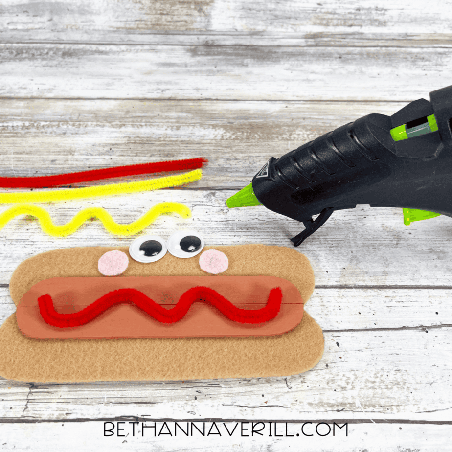 Pipe cleaners glued in wavy lines on hot dog craft for ketchup and mustard