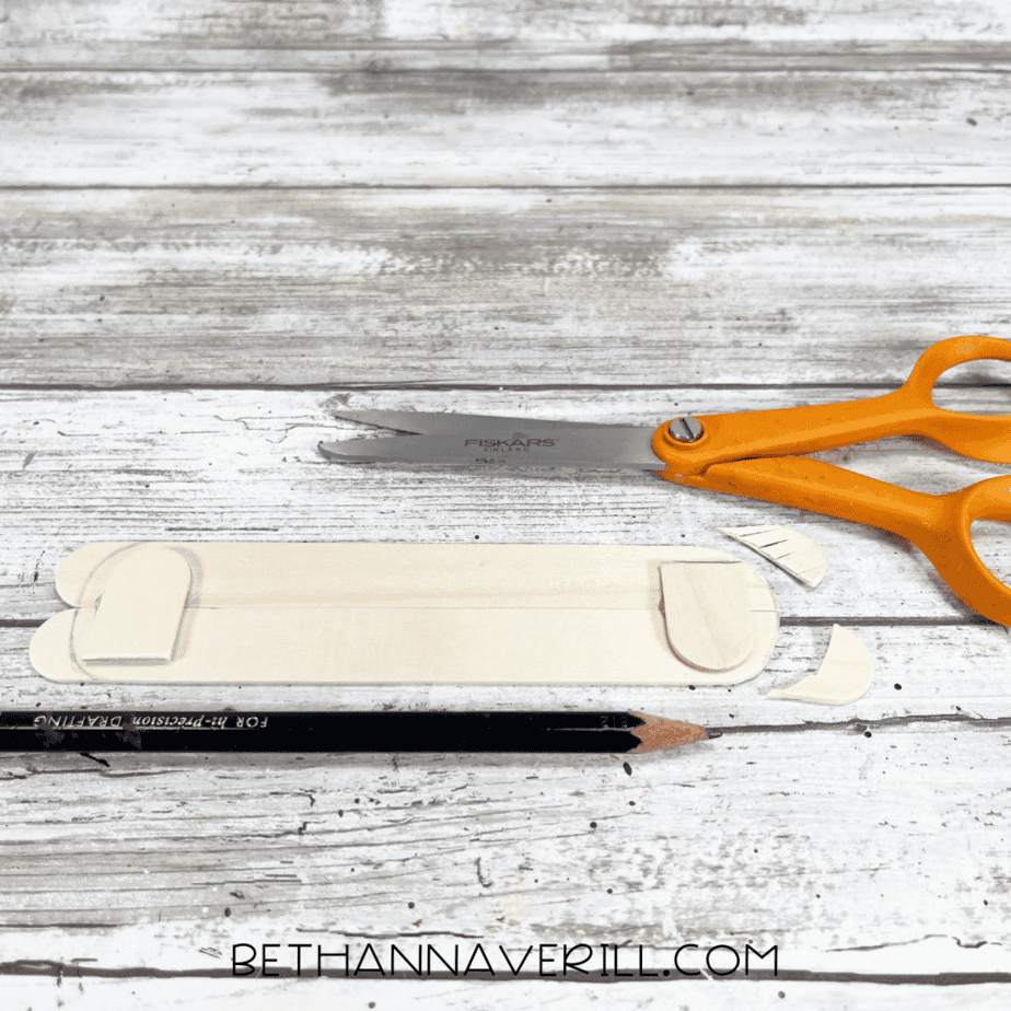 Back view of hot dog craft base with extra craft stick supports trimmed