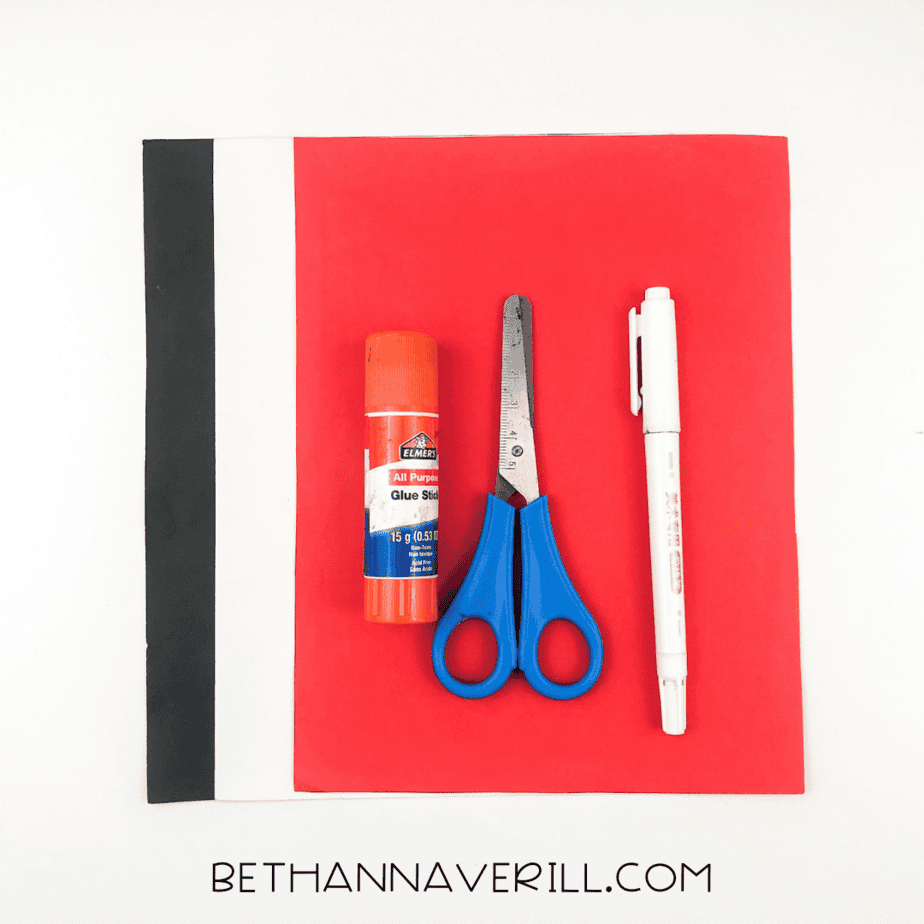Materials for ladybug craft: red, black, white paper, glue stick, scissors, and black marker