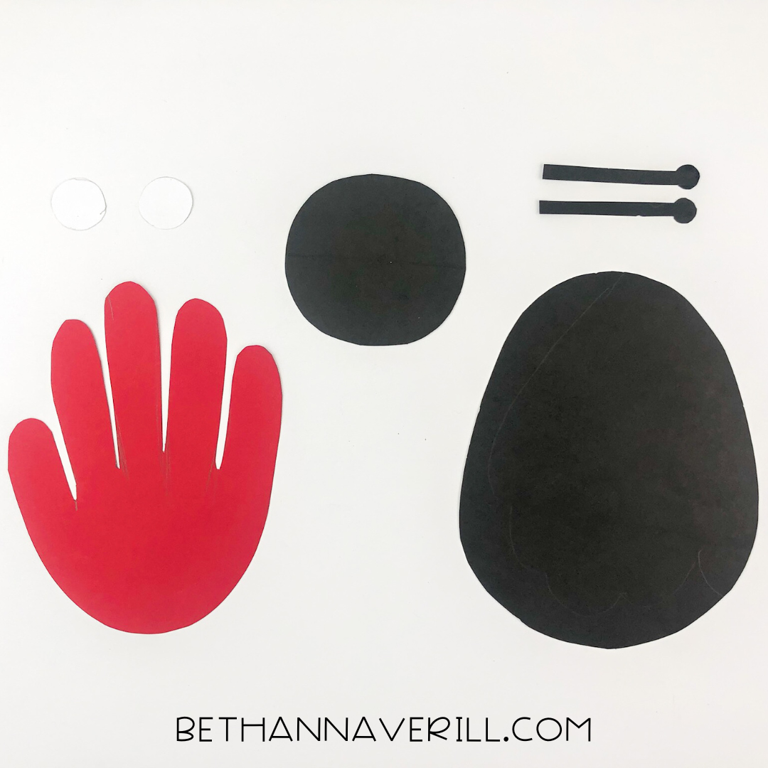 Cut-out pieces: red handprint, black body and head, white circles for eyes, and black antennae