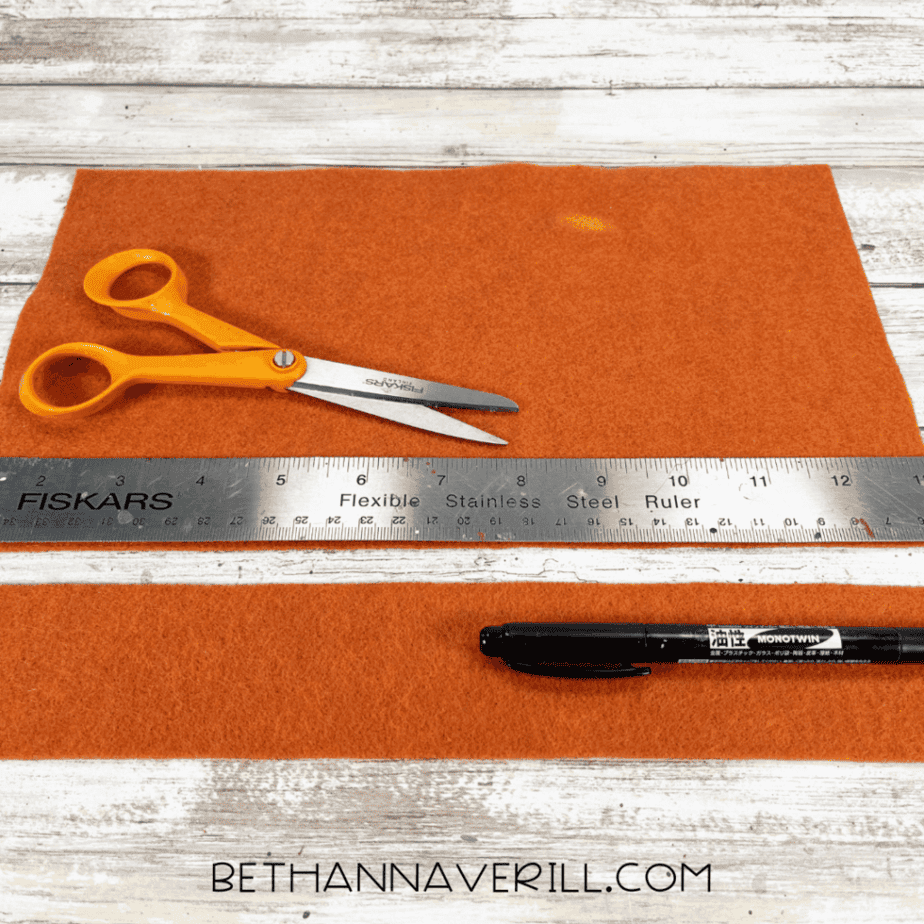Orange felt being measured for mane strips.