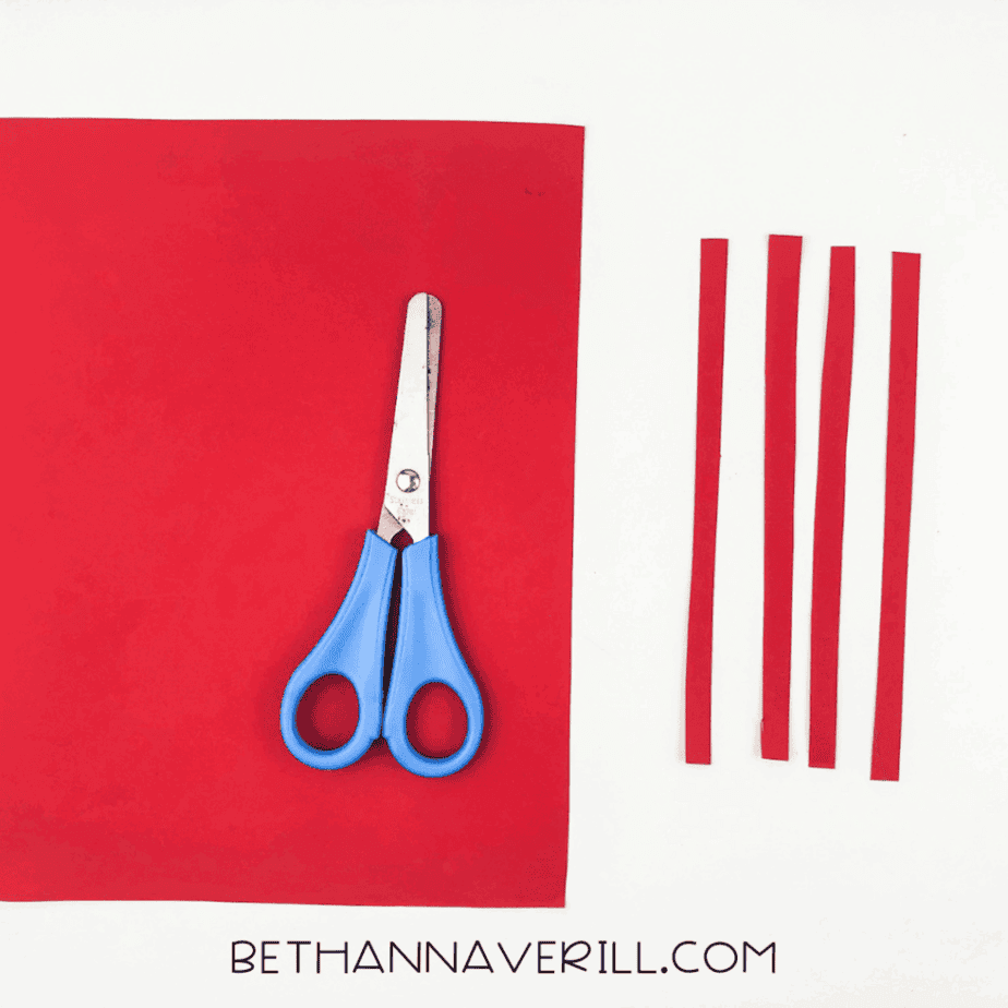 Red paper strips and scissors laid out for lobster legs.