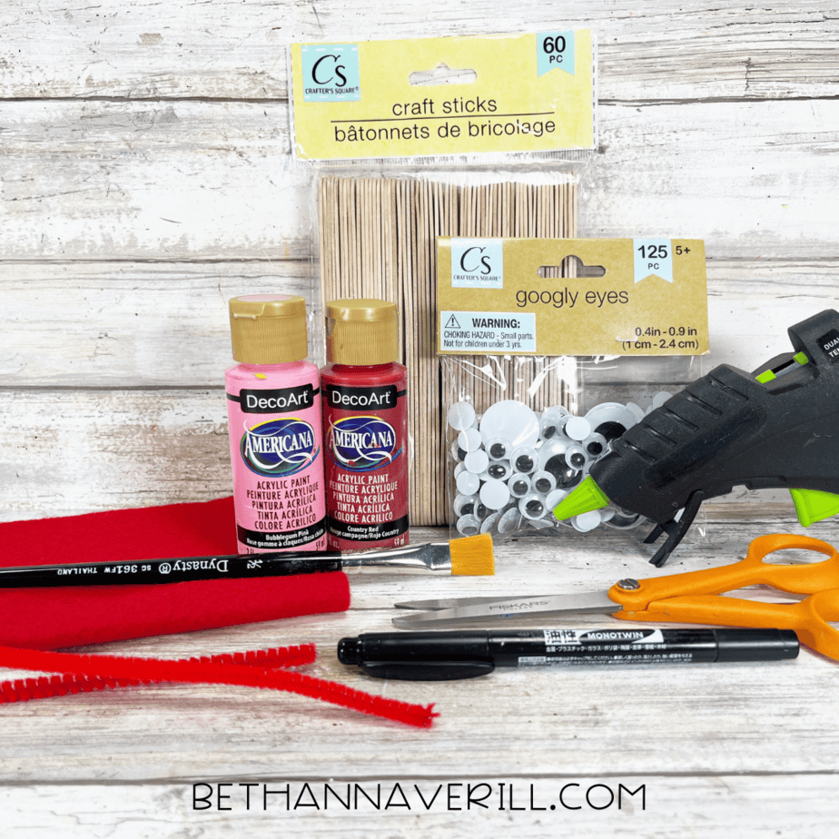 Supplies for popsicle stick lobster craft including paint, felt, and googly eyes