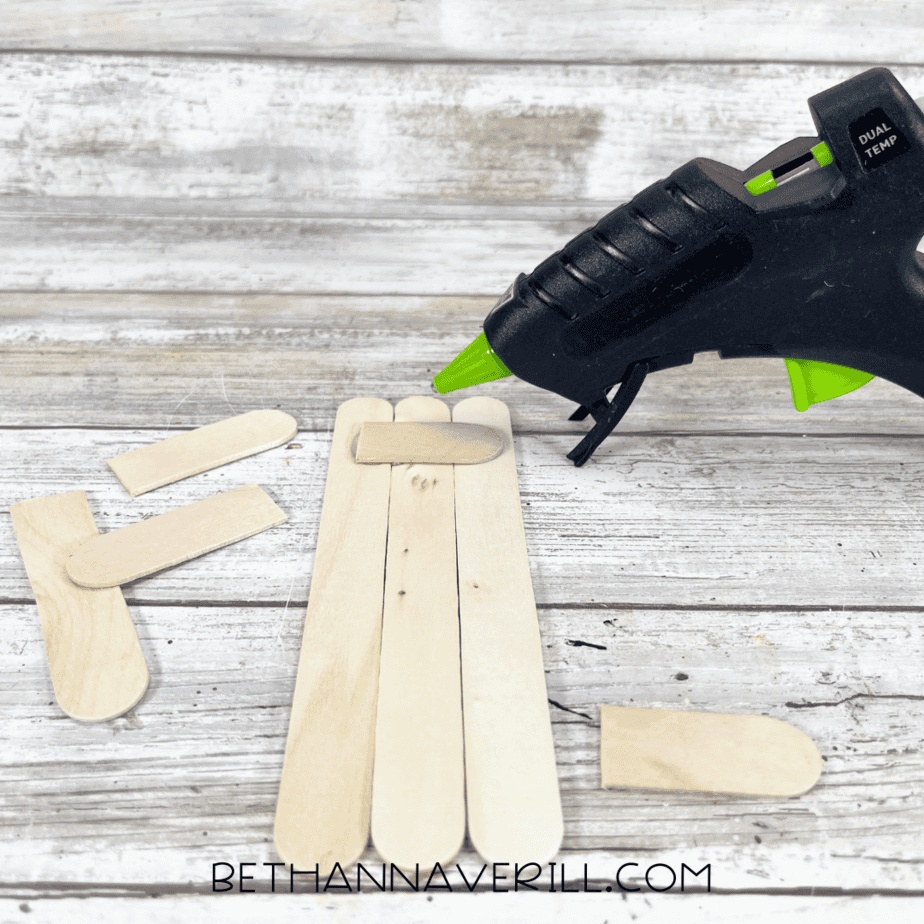 Craft sticks glued together with hot glue gun beside them