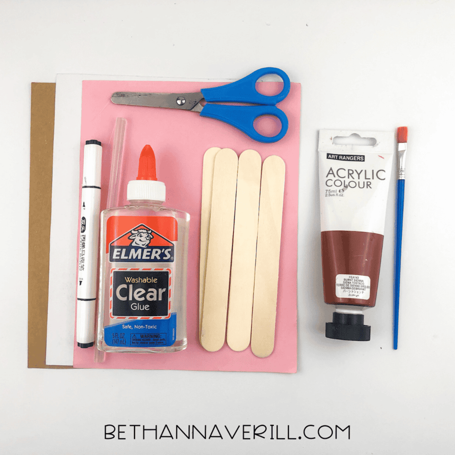 Moose popsicle stick craft supplies including popsicle sticks, brown paint, glue, scissors, and construction paper.