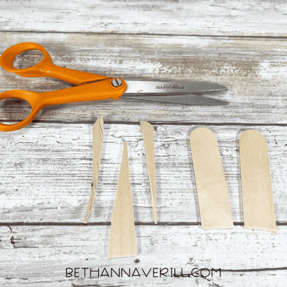 Cut pieces of craft sticks shaped like flippers and a narwhal tusk.