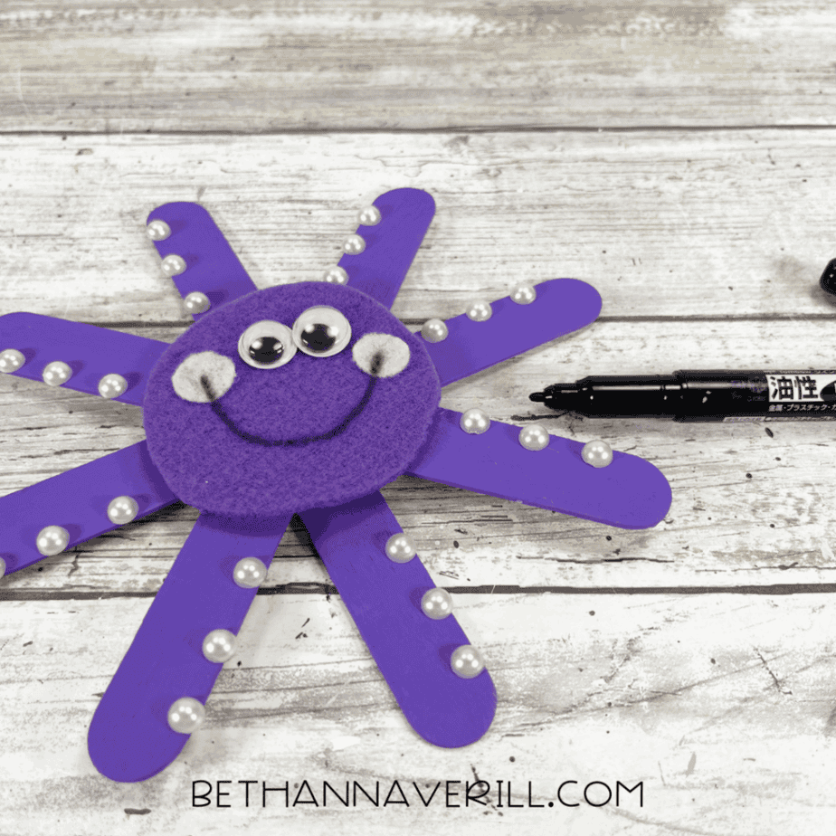 Adding smile with black marker on octopus face.