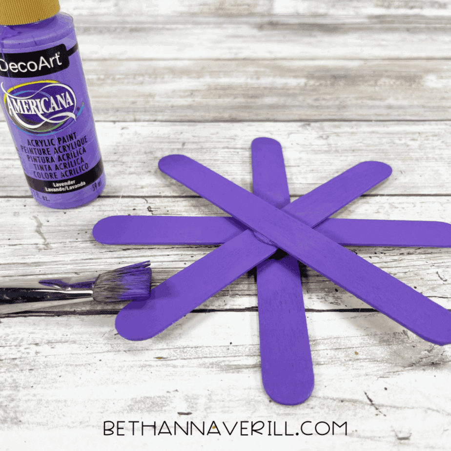 Painting the popsicle stick base purple.