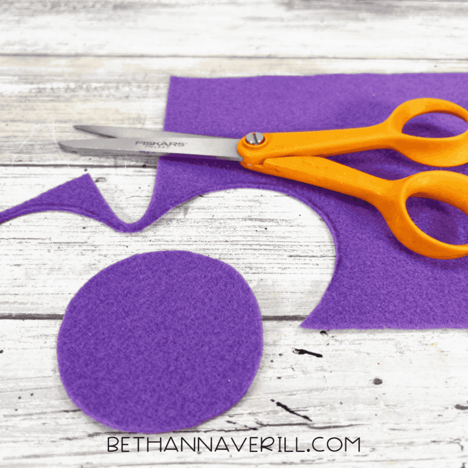 Purple felt circle cut out with scissors.