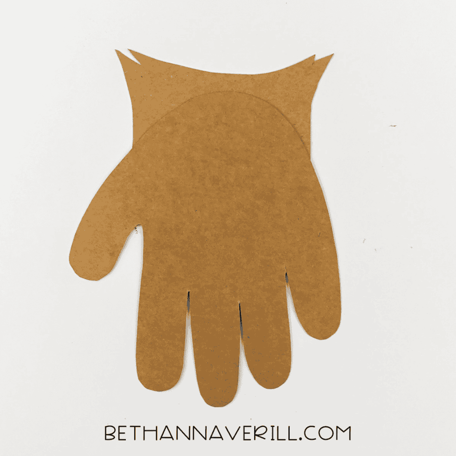 Brown handprint and pointy ear tufts glued together to form owl shape