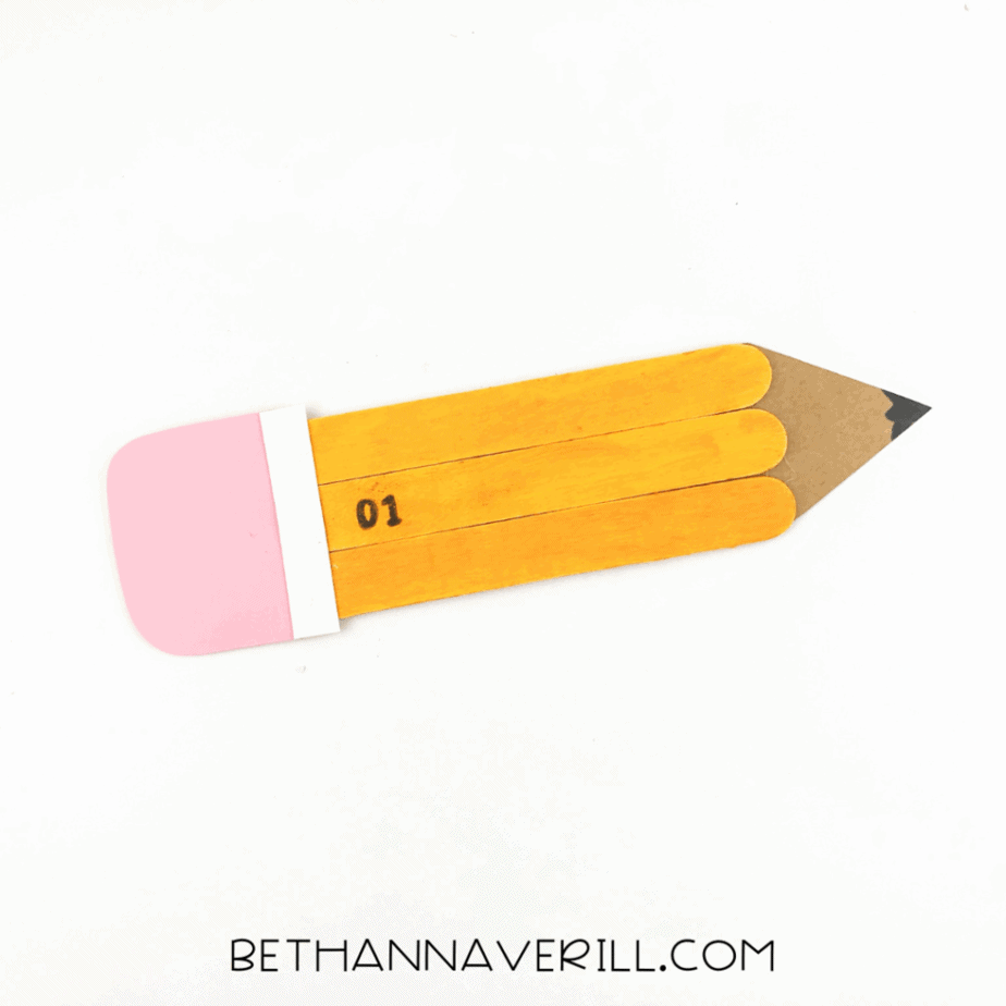 Finished popsicle stick pencil craft with black details drawn on.