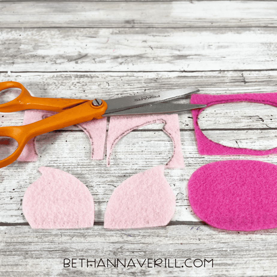 Cut-out felt shapes for the pig’s ears and snout with scissors beside them.