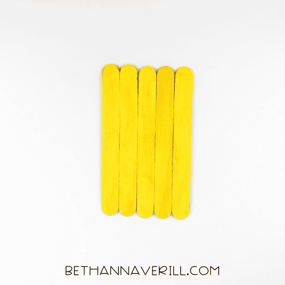 Six yellow sticks glued side by side forming the pineapple base.