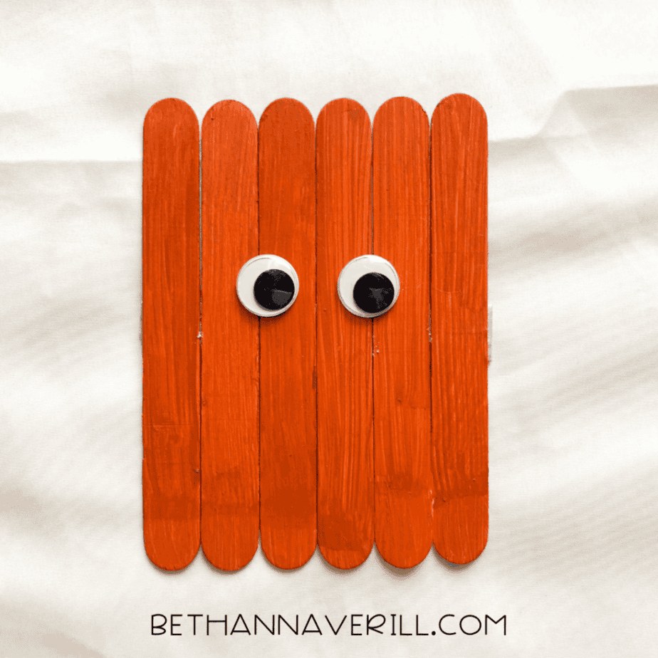 googly eyes added to the front of the pumpkin popsicle stick base