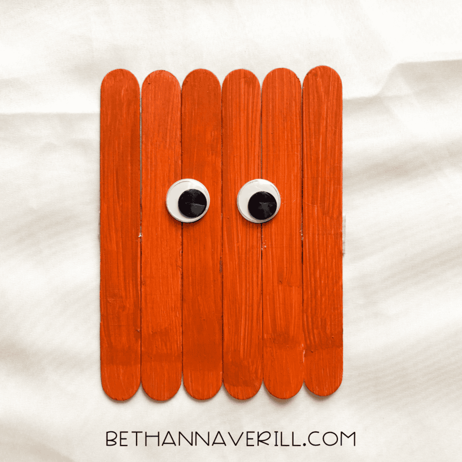 googly eyes added to the front of the pumpkin popsicle stick base