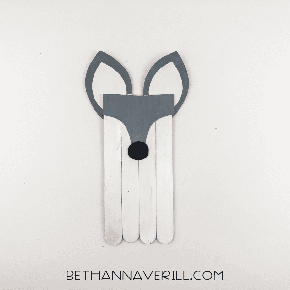 Gray face mask and black circle nose glued to the top of the panel.