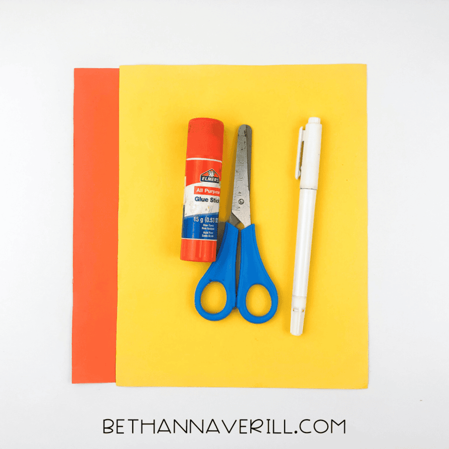 Materials for seahorse craft: red and yellow paper, glue stick, scissors, pencil.