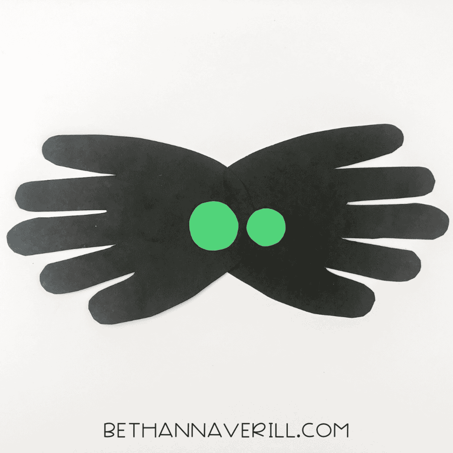 Green paper eyes glued to center of black spider body