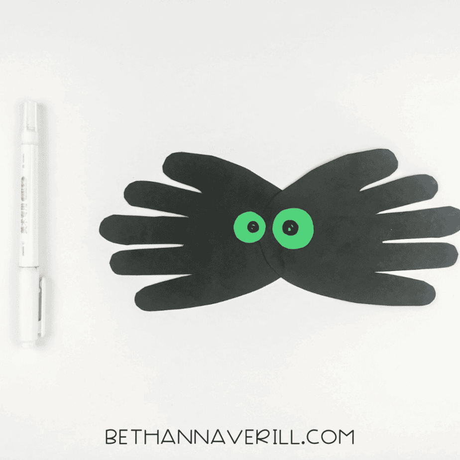 Black pupils drawn inside the green eyes with a black marker
