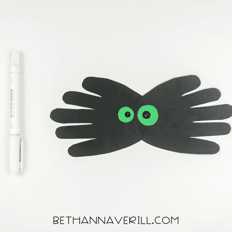 Black pupils drawn inside the green eyes with a black marker