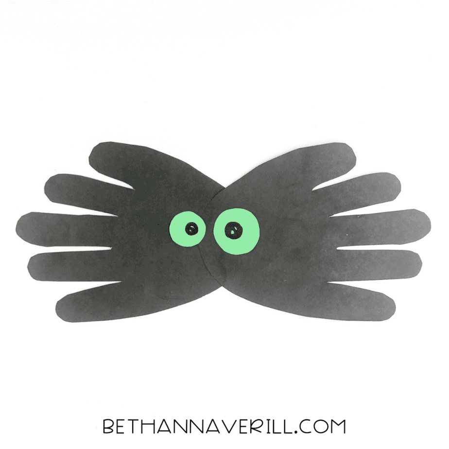 Completed spider handprint craft with green eyes and black pupils