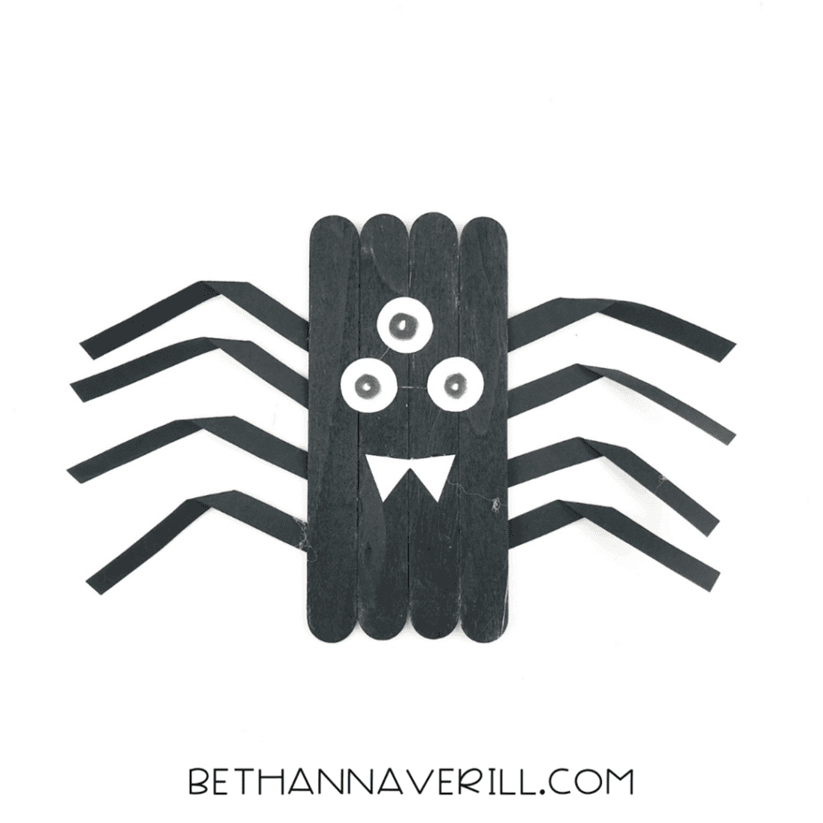 spider with three eyes and a white paper mouth with pointed fangs.
