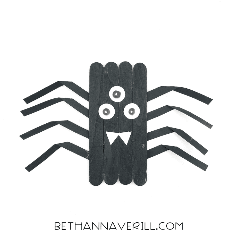 spider with three eyes and a white paper mouth with pointed fangs.