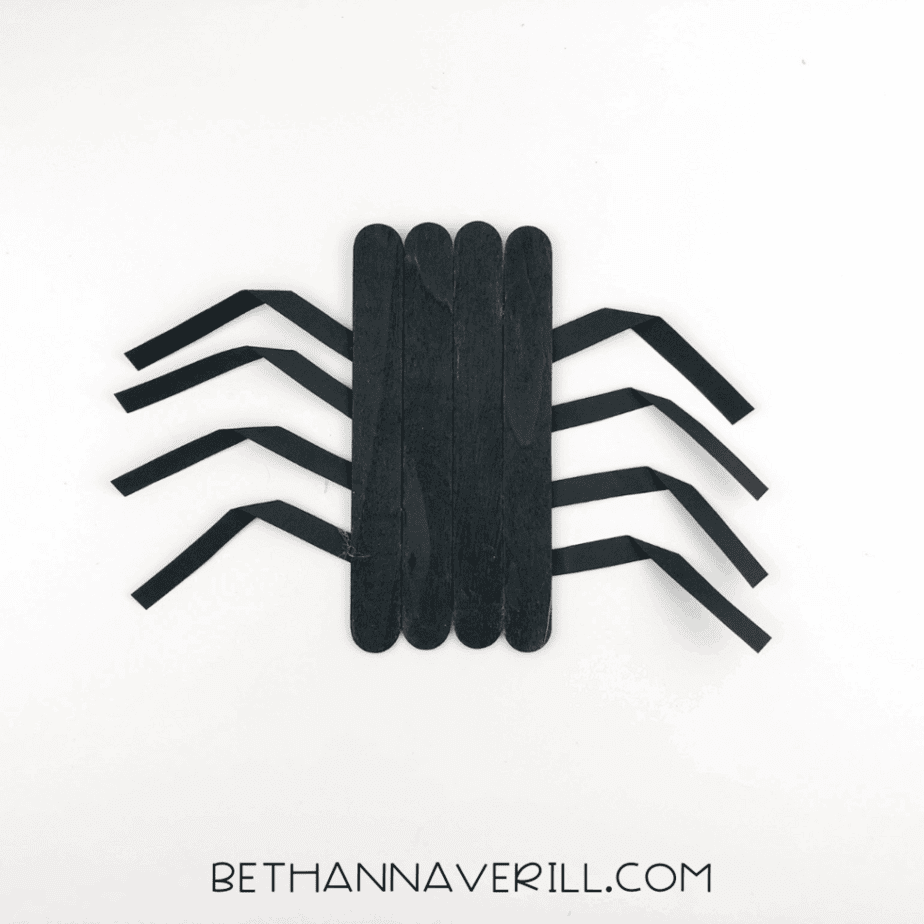 Spider body with eight folded paper legs glued to the back, four on each side.