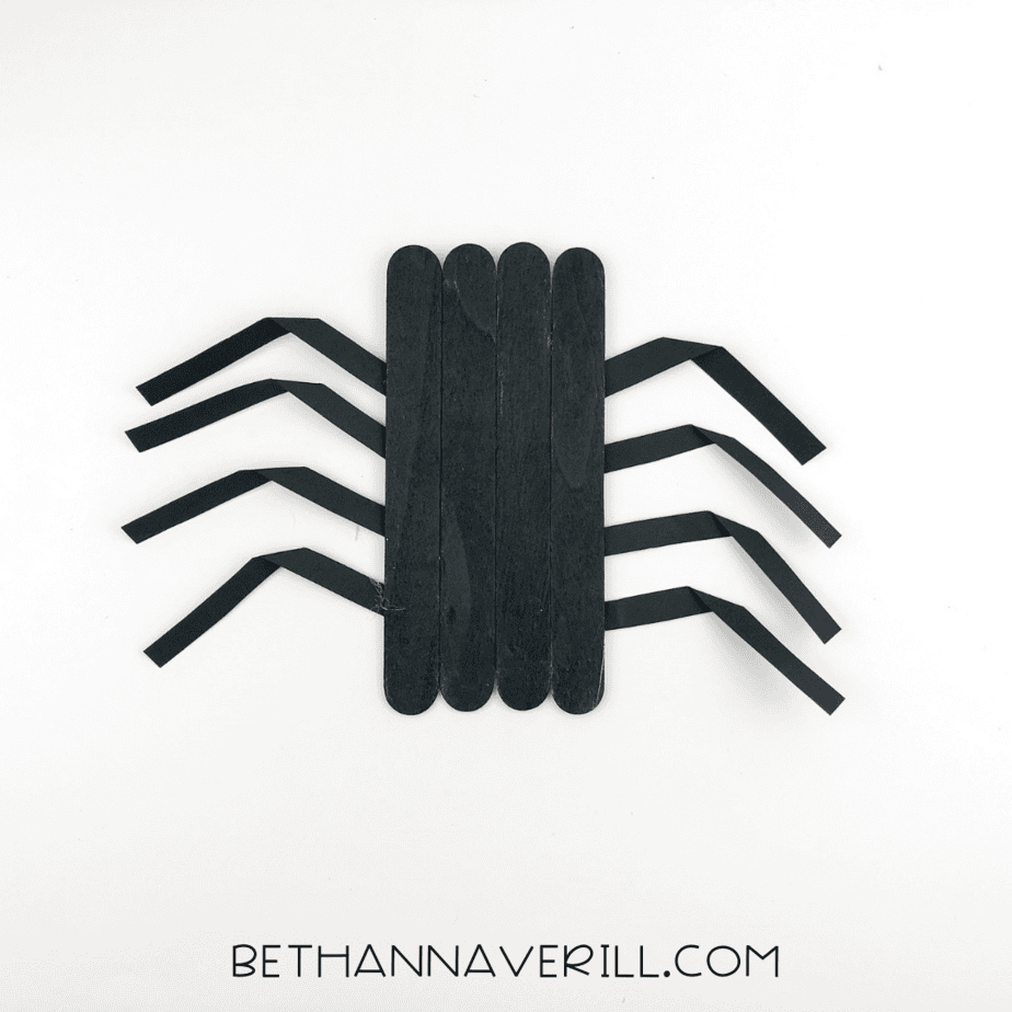 Spider body with eight folded paper legs glued to the back, four on each side.