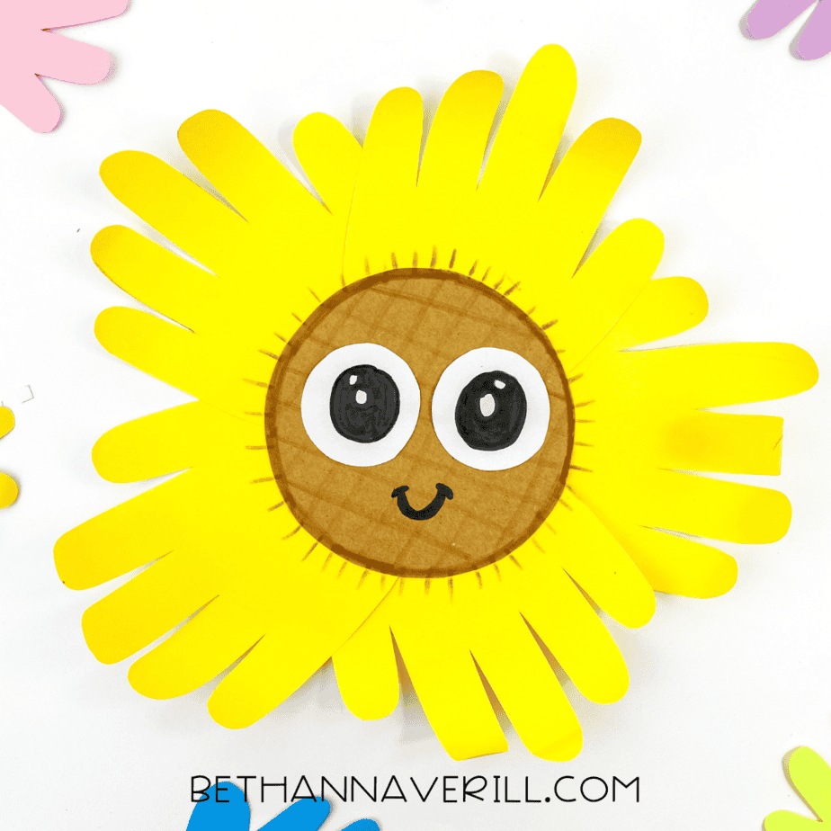Completed sunflower handprint craft surrounded by colorful paper hands