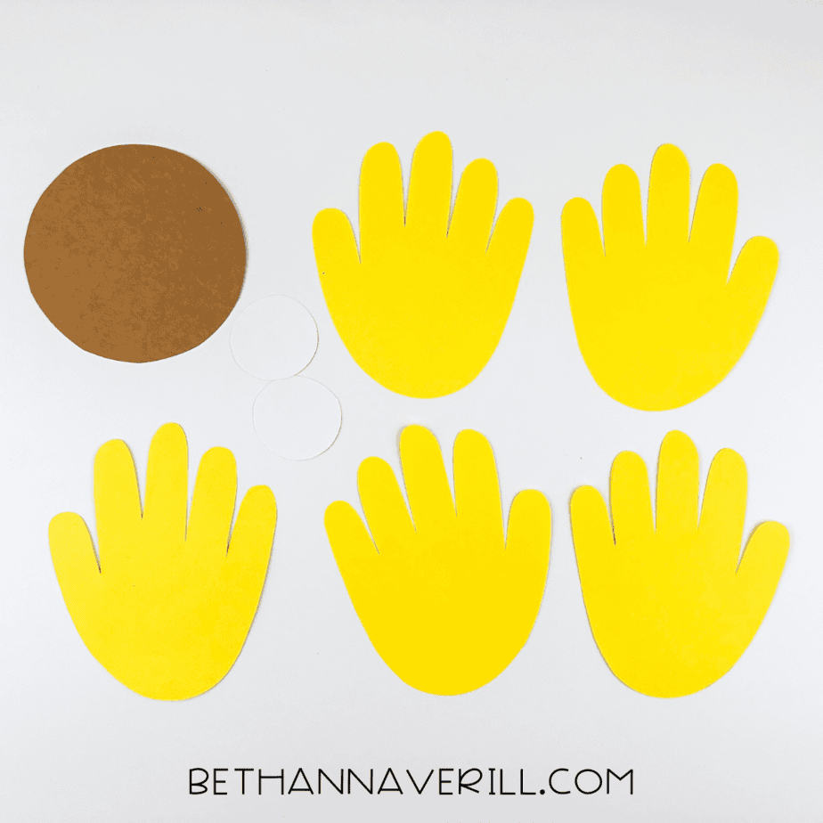 Cutouts of yellow handprints and brown and white circles ready for crafting