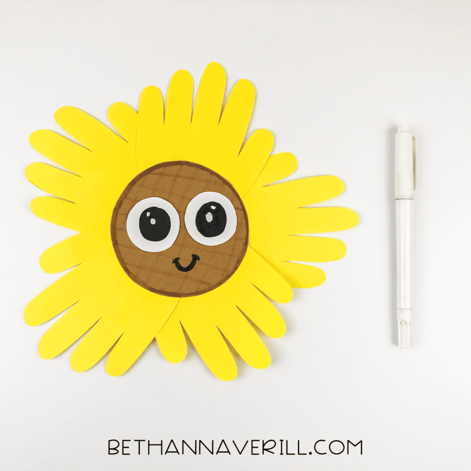black marker used to draw sunflower face with big eyes and a cute smile