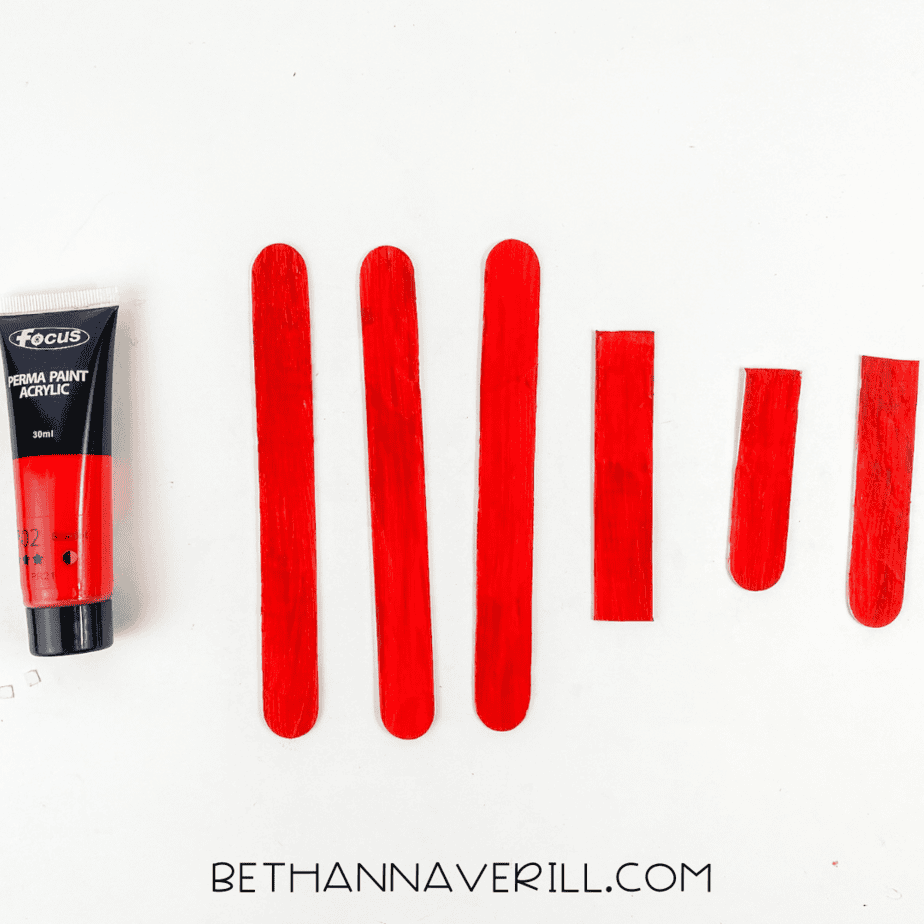 Painted red popsicle sticks, including three trimmed ones.