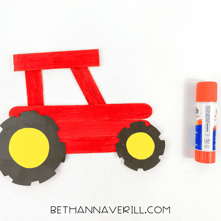 Wheels glued onto the popsicle stick tractor.