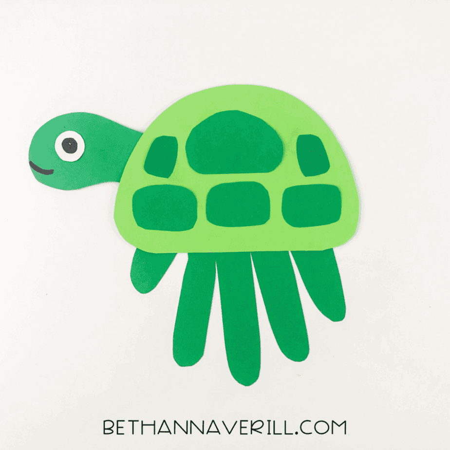 Completed green turtle handprint craft on white background.
