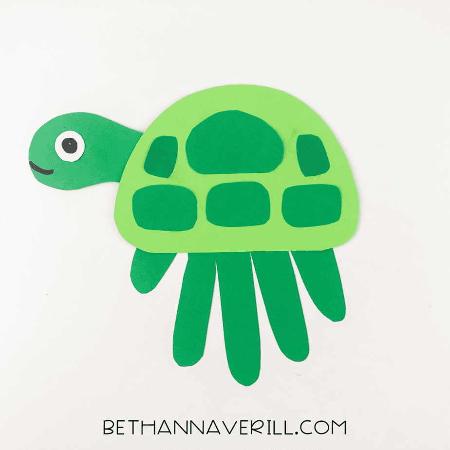 Completed green turtle handprint craft on white background.