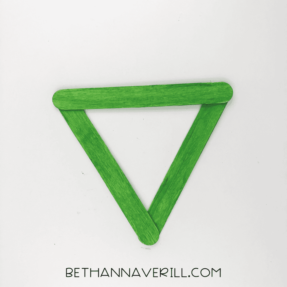 Popsicle sticks arranged into a triangle shape.
