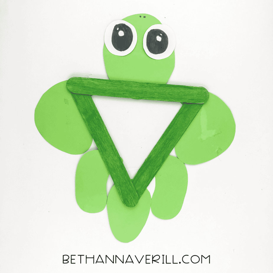 Paper pieces glued behind the triangle to make a turtle shape.