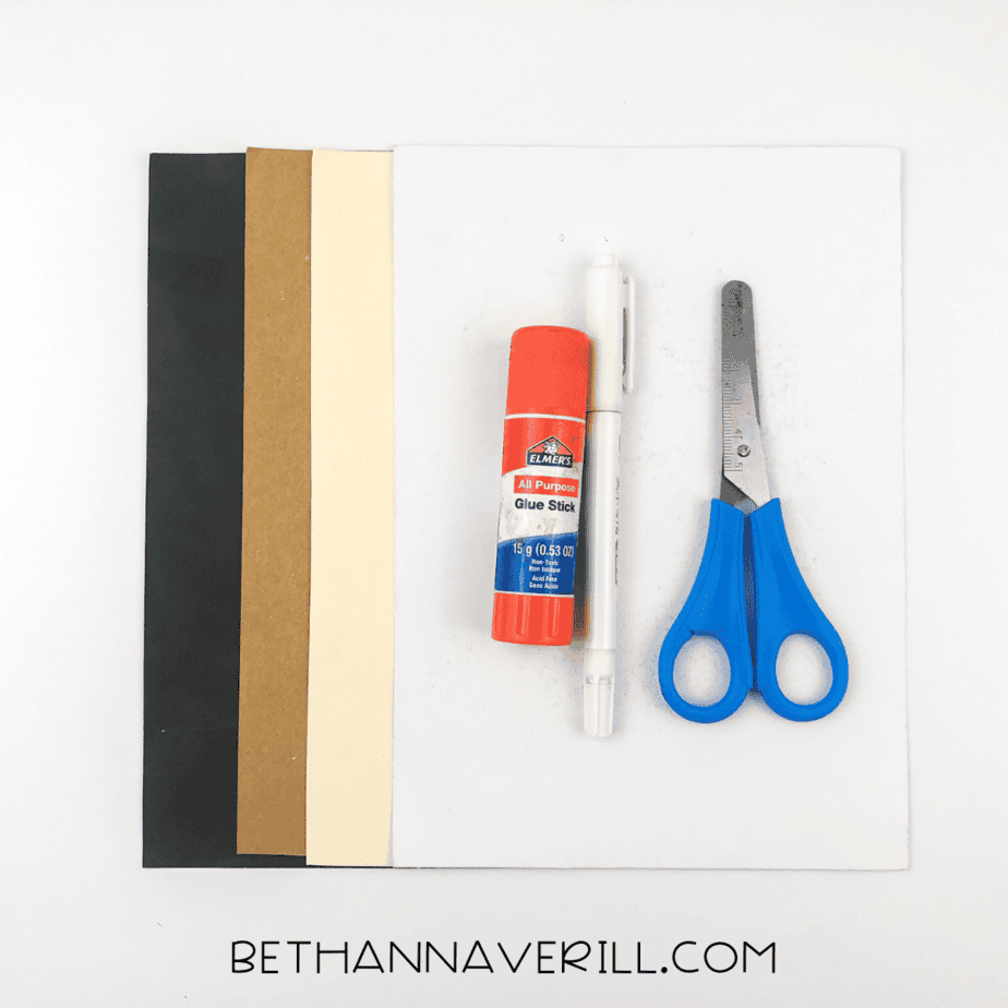Materials laid out: brown, white, and black construction paper, glue stick, scissors, and pencil.