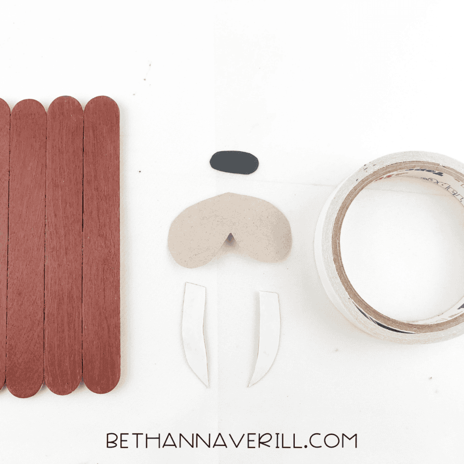 Painted base next to snout, nose, and tusks made of construction paper.