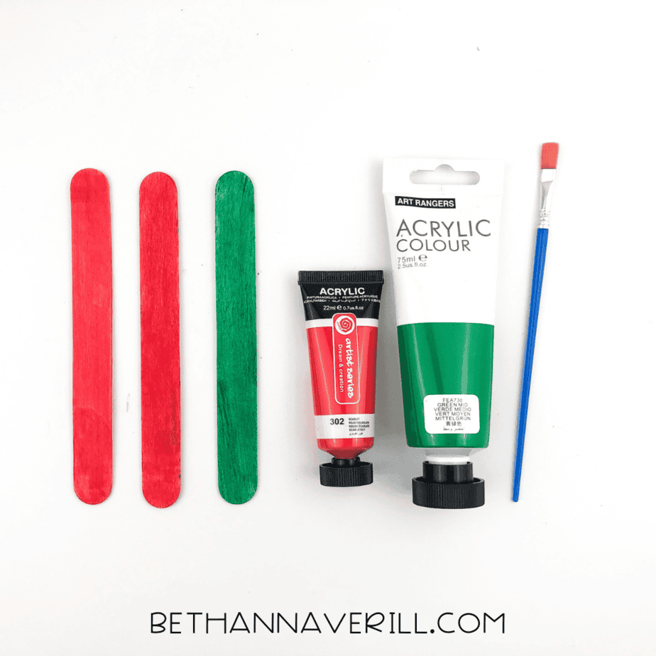Painted craft sticks: two red and one green.