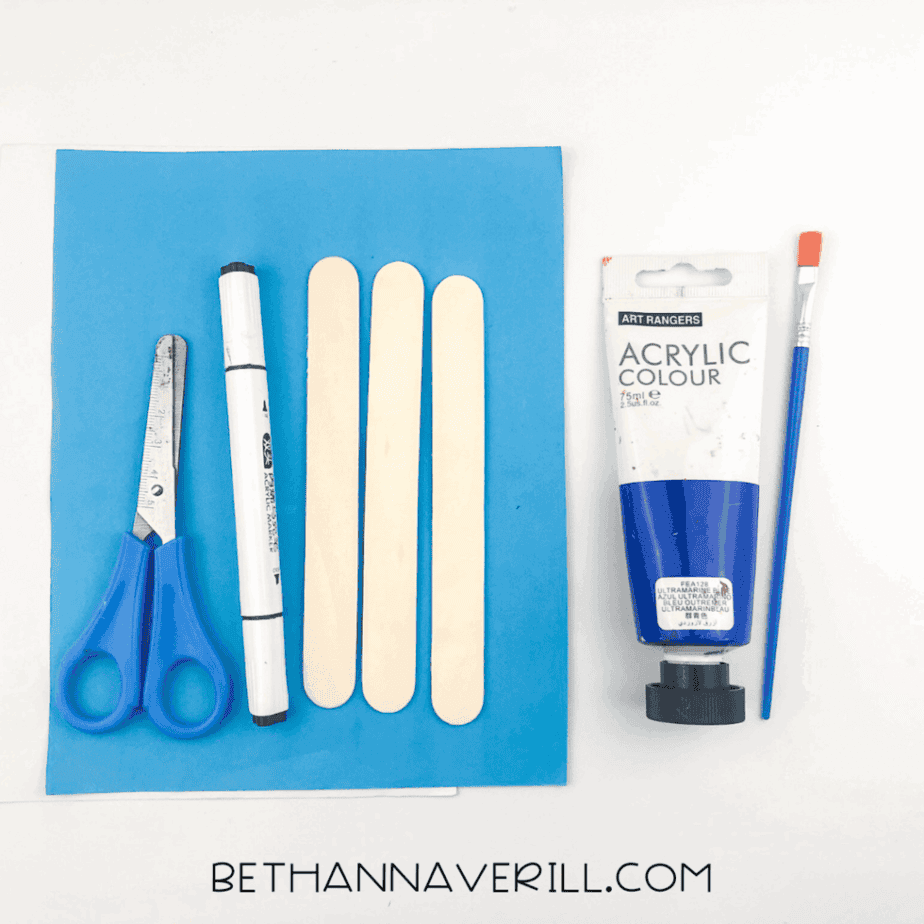 Materials needed: scissors, blue paper, popsicle sticks, black marker, blue acrylic paint, and a paintbrush.