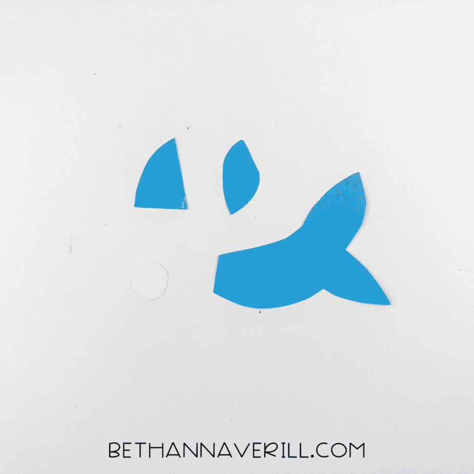 Blue construction paper pieces cut into fins, tail, and a small white eye circle.
