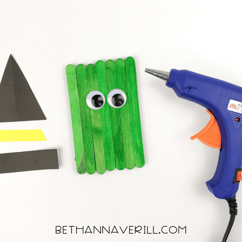 googly eyes glued on to the popsicle stick platform to create the face