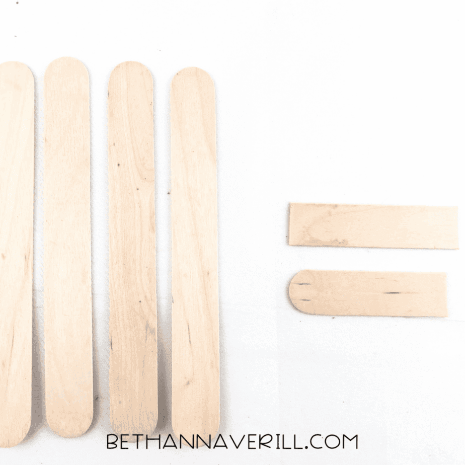 Four craft sticks lined up with a fifth stick broken in half
