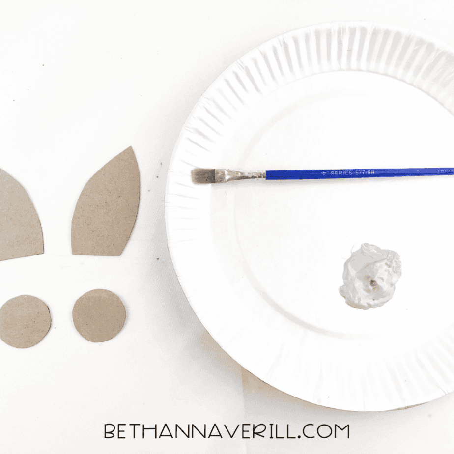 Ear pieces being painted gray on a paper plate