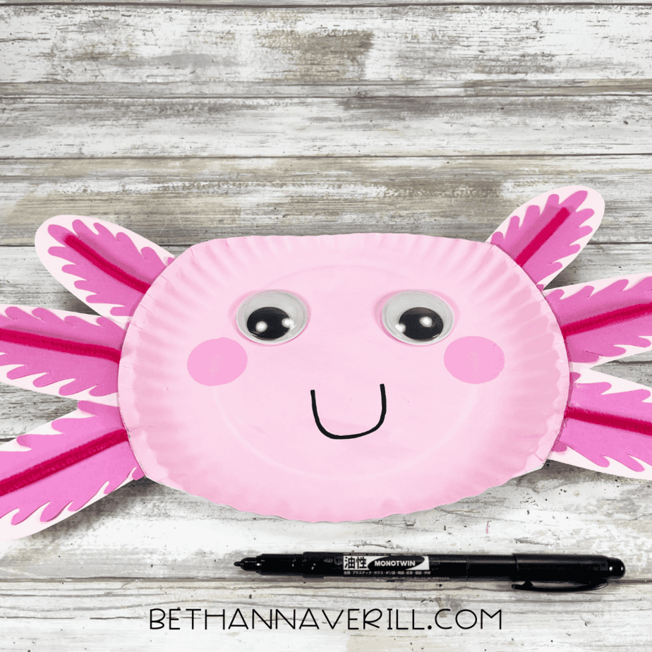 Completed axolotl paper plate craft with big googly eyes and a happy smile.