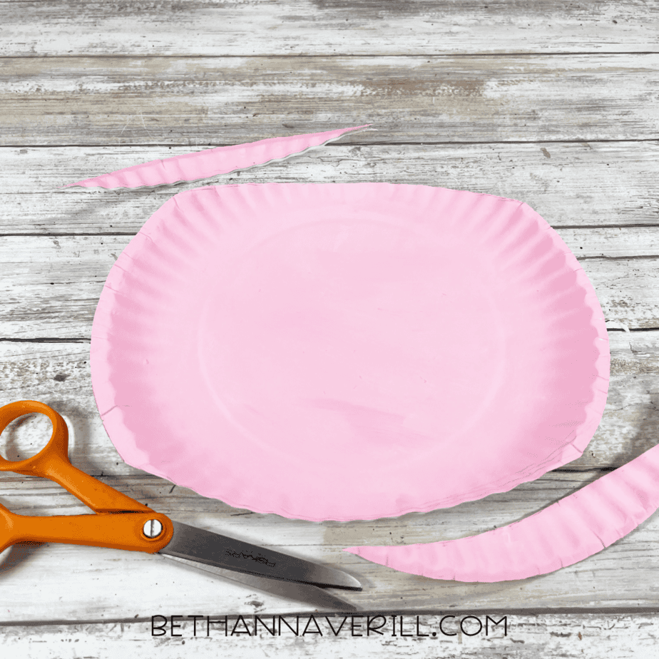 Painted paper plate with edges trimmed off using scissors.