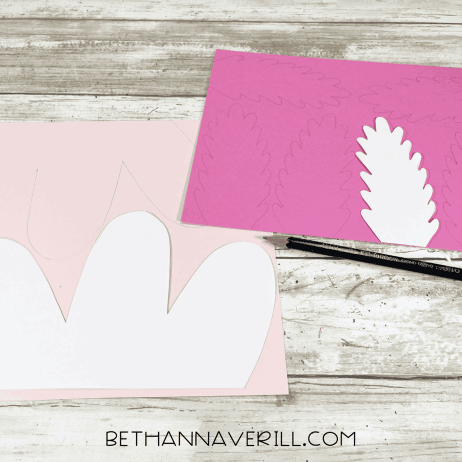 Pink paper traced with axolotl gill shapes next to templates.