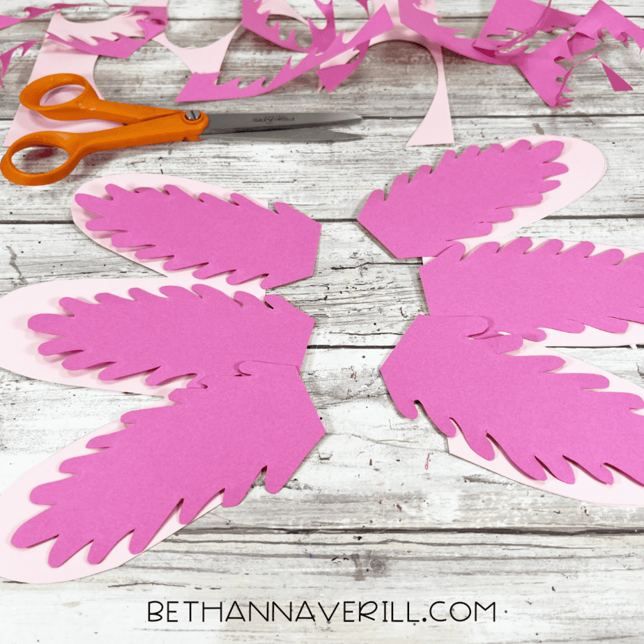 Cut out pink paper gills layered together on a table.